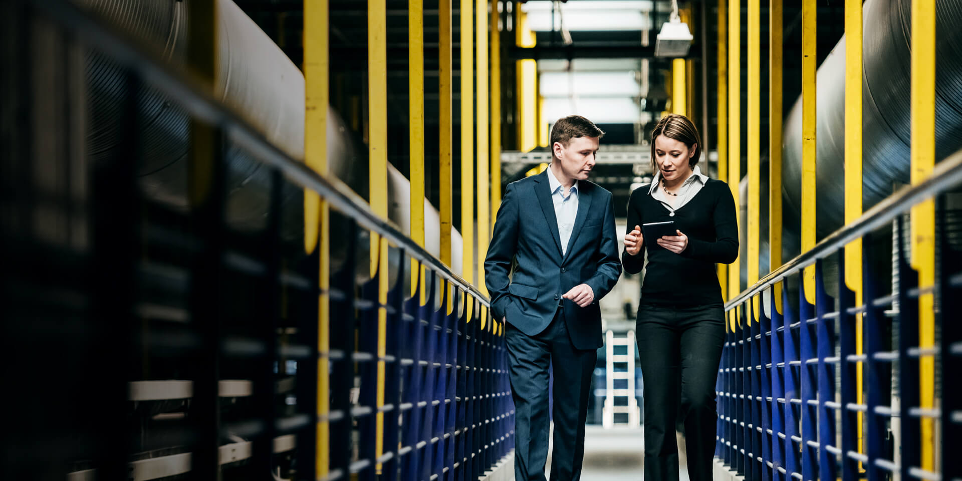 A man and a woman looking at financials on a tablet device.