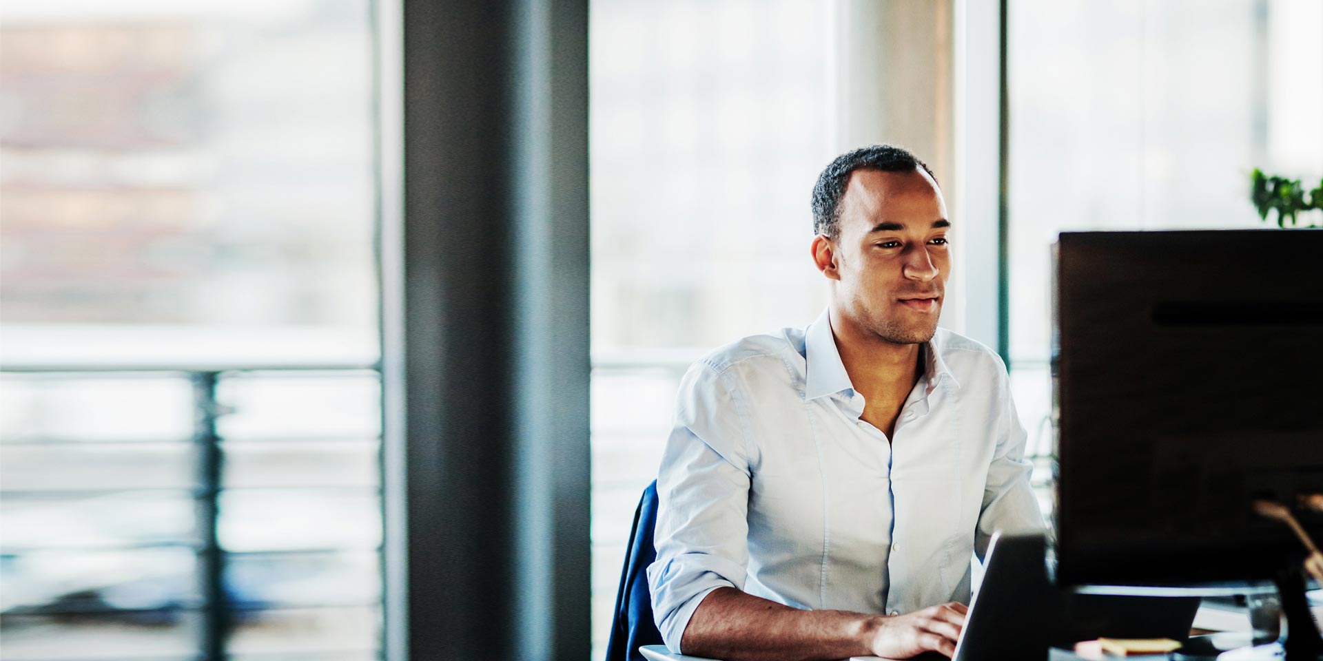 A businessman at his computer working with a payables solution product to easily deliver payroll and pay vendors