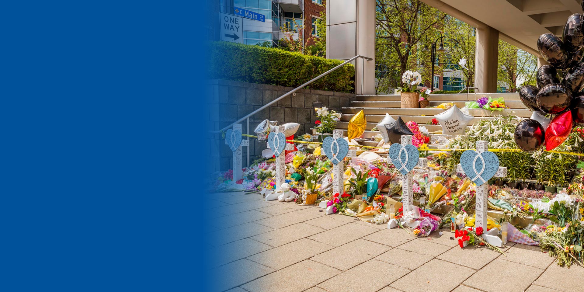 Flowers and remembrance adorn the entrance to the building