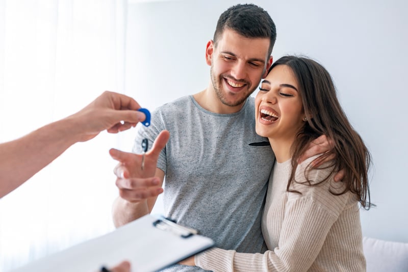 A couple getting handed keys to their new home