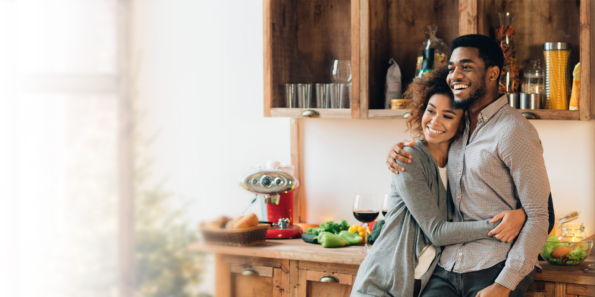 A couple hugging in their kitchen